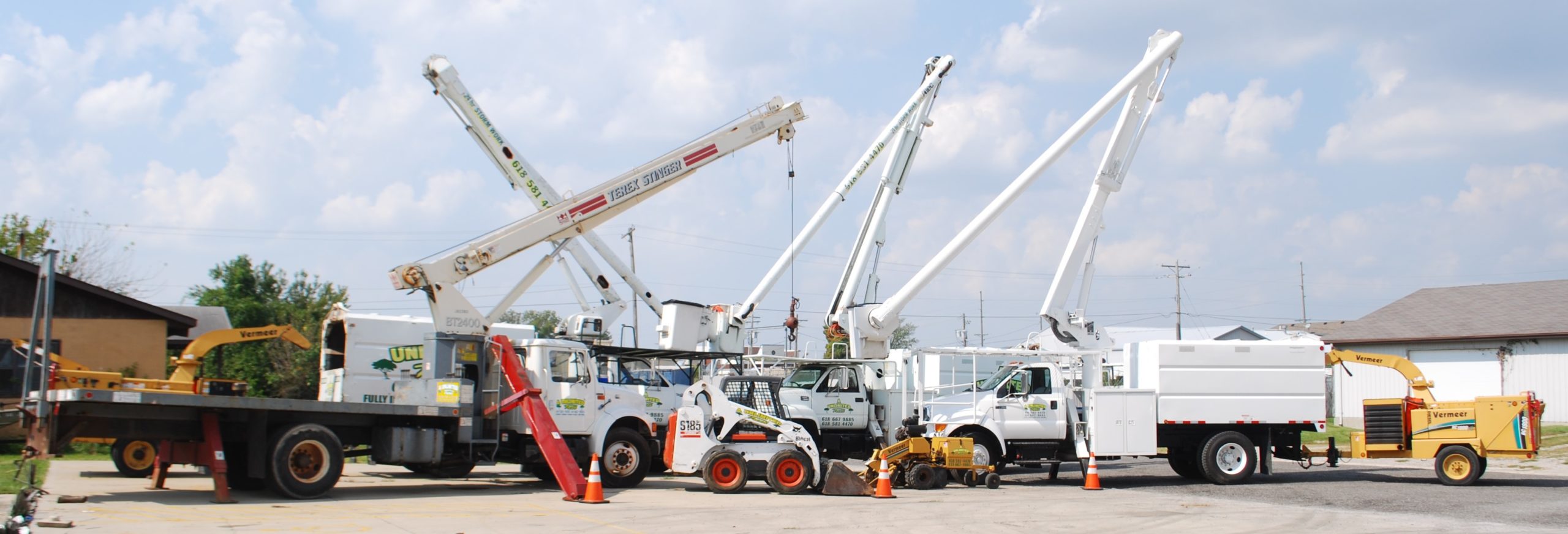 Picture of white tree trimming trucks lined up at a tree removal company in Troy, IL.