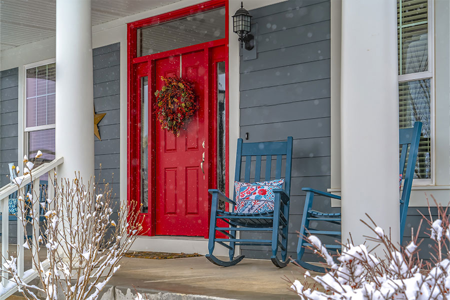 A red door connected to a residential home in Glen Carbon, IL that is trying to improve the curb appeal of a yard in the winter.